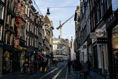 During the day, people walking in the streets of between buildings
